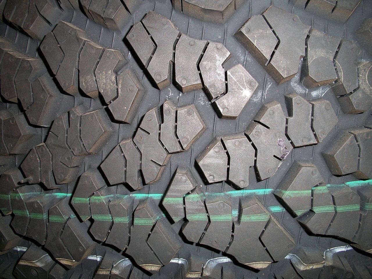 Close-up of tire tread and sidewall stacked in a shop, showing wear and age detail