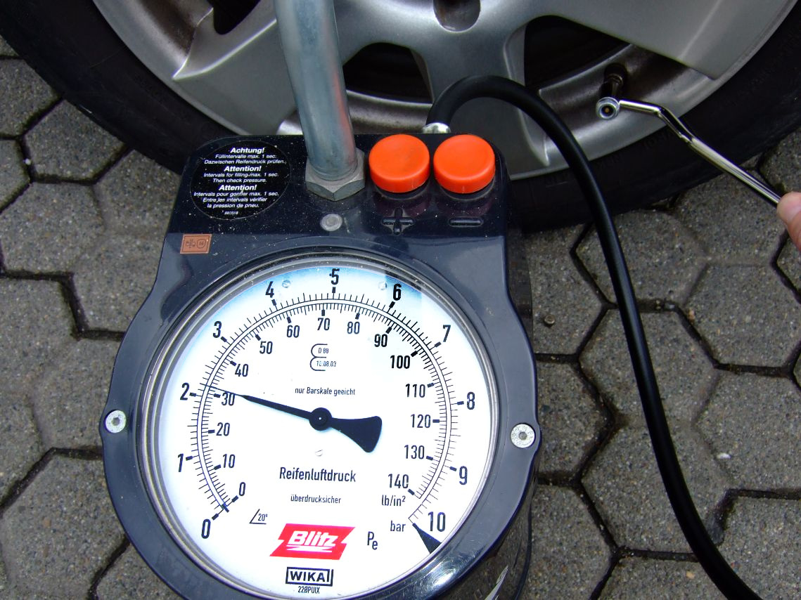 Checking car tire pressure with a dial gauge