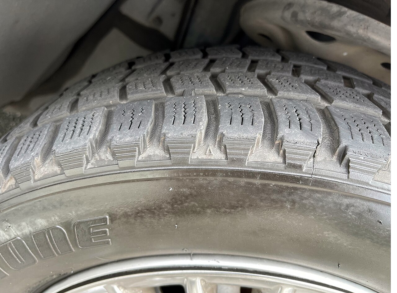 Close-up of tread wear indicator bars raised in a tire's tread grooves