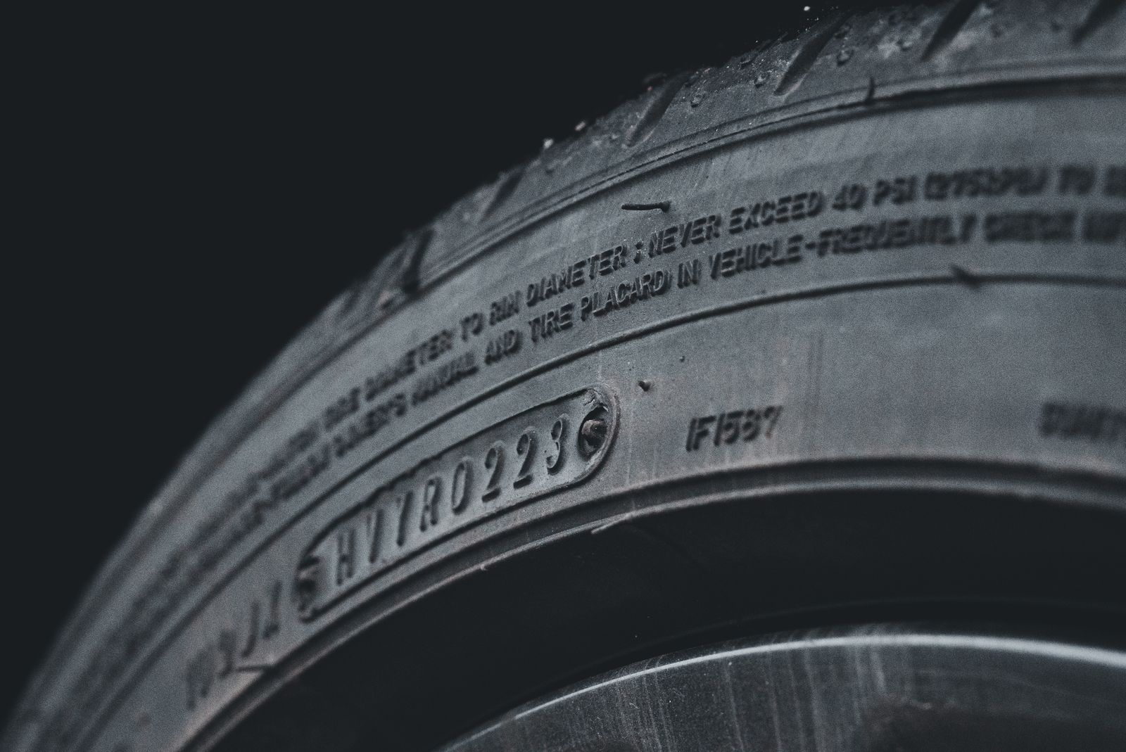 Close-up of a tire sidewall showing the molded UTQG treadwear, traction and temperature ratings